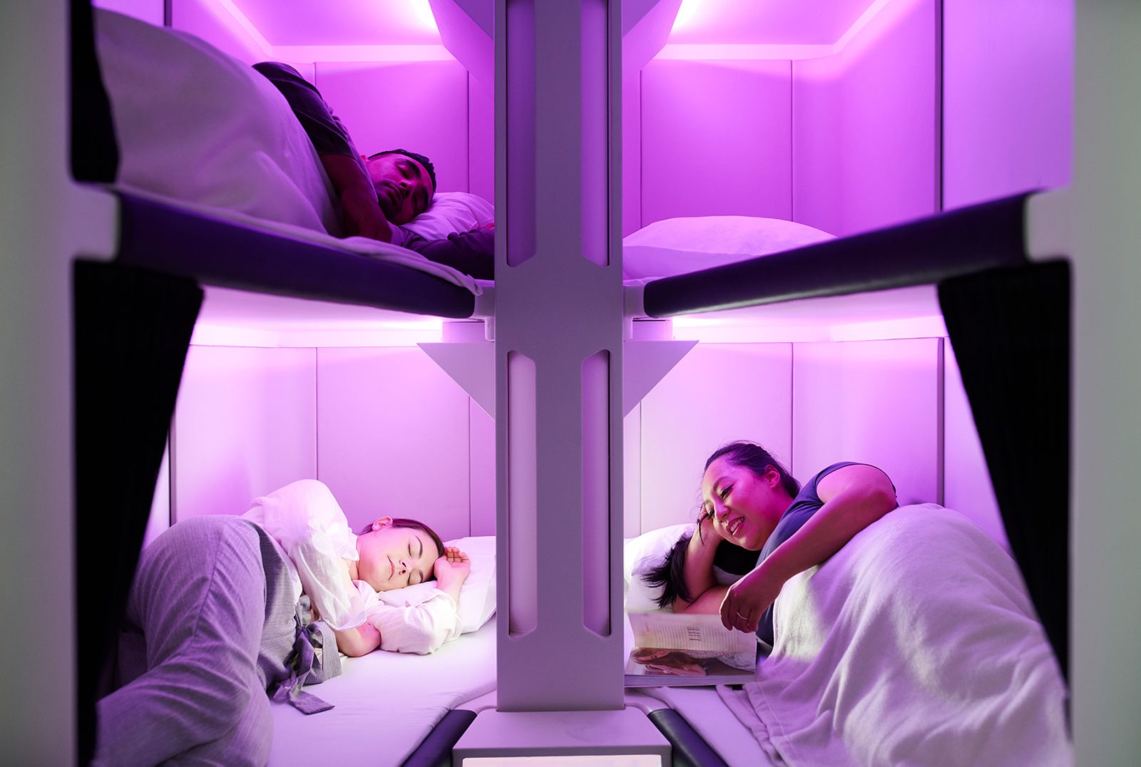 Air New Zealand Skynest economy bunk bed sleep pods with purple mood lighting showing passengers sleeping