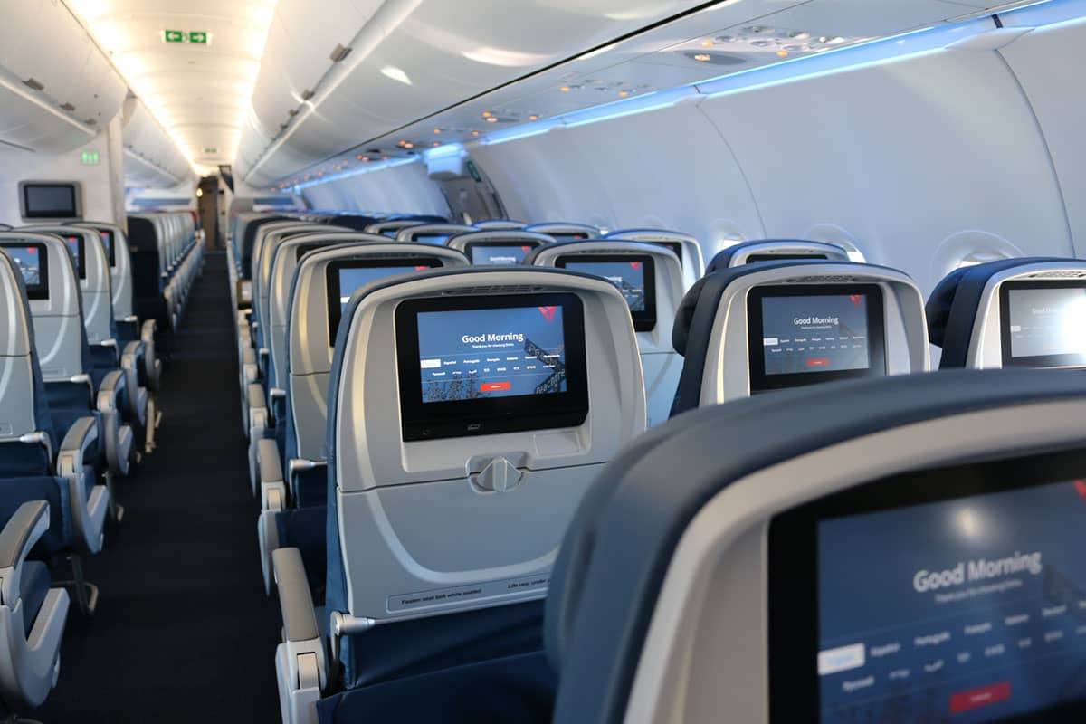 Delta Airbus A321ceo cabin with Delta Sync seatback IFE screens showing Good Morning display