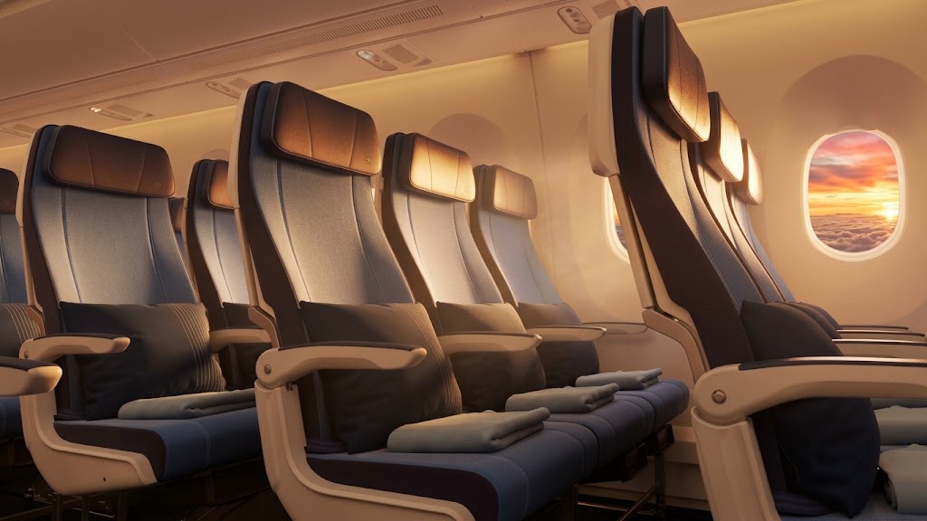 Airbus A350 economy seats in blue and grey with pillows and blankets beside a window at sunset