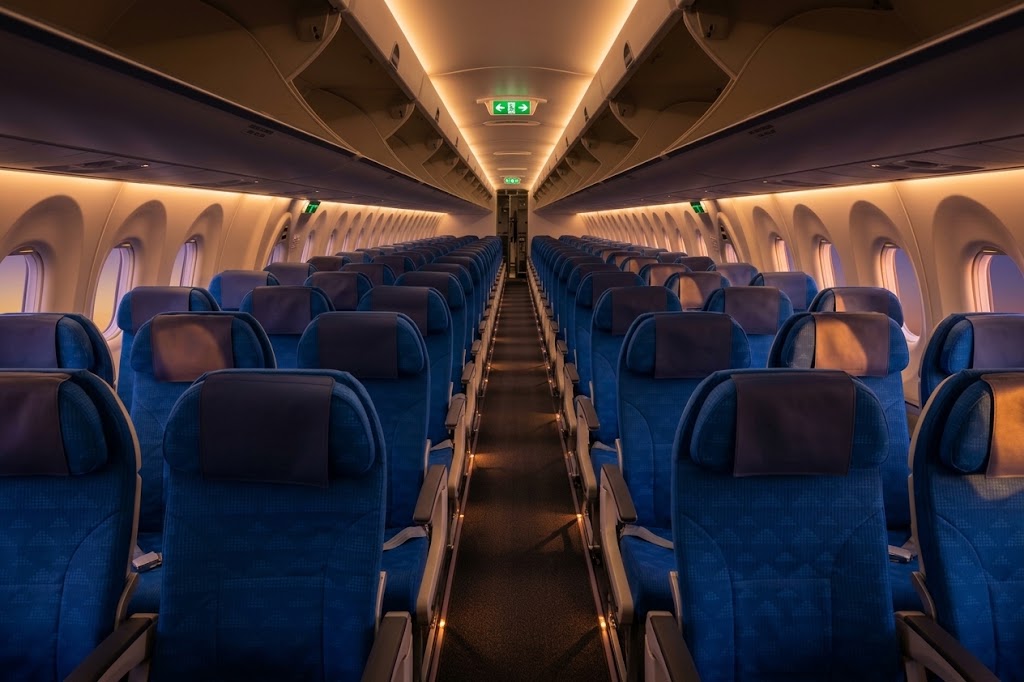 Korean Air Airbus A220-300 economy cabin looking aft down the aisle, blue seats two abreast on the left and three on the right