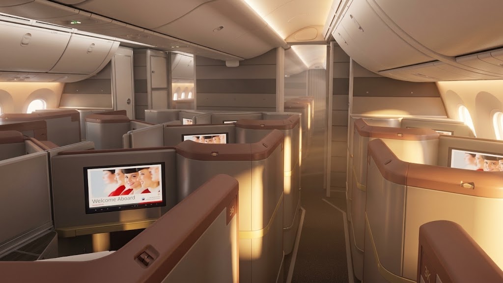 Royal Jordanian Boeing 787-9 Crown Class cabin, one-two-one reverse-herringbone suites with high privacy shells and seatback screens along a warmly lit aisle