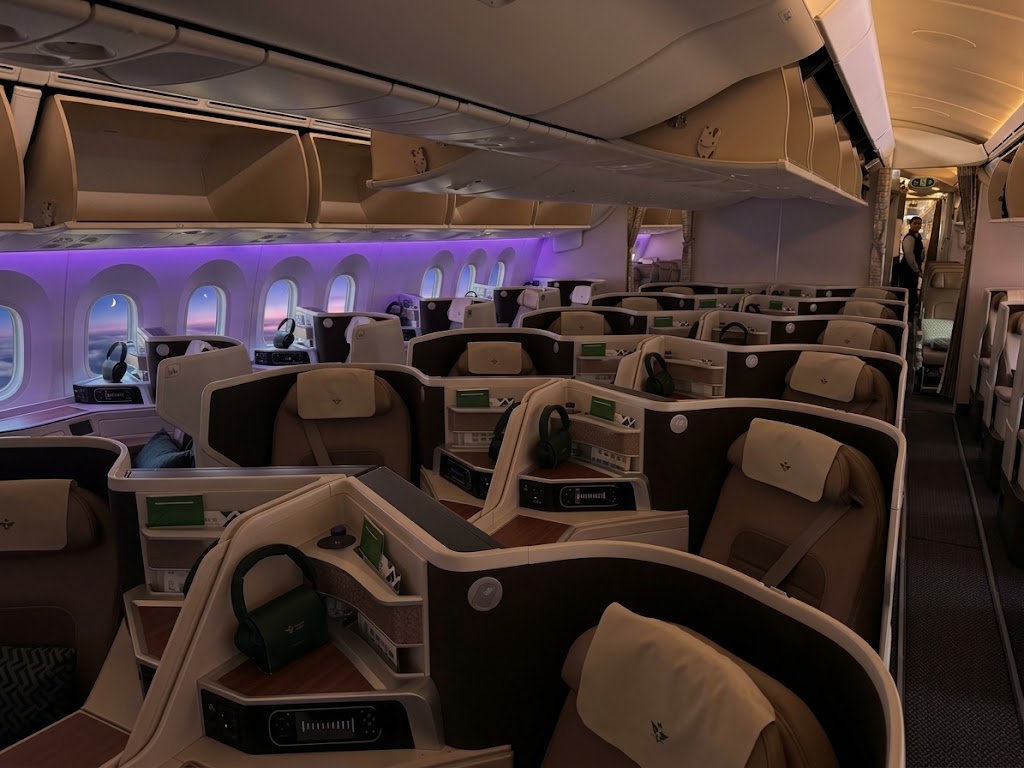 Saudia Boeing 787-10 business cabin, one-two-one Super Diamond reverse-herringbone suites in cream and brown under purple mood lighting