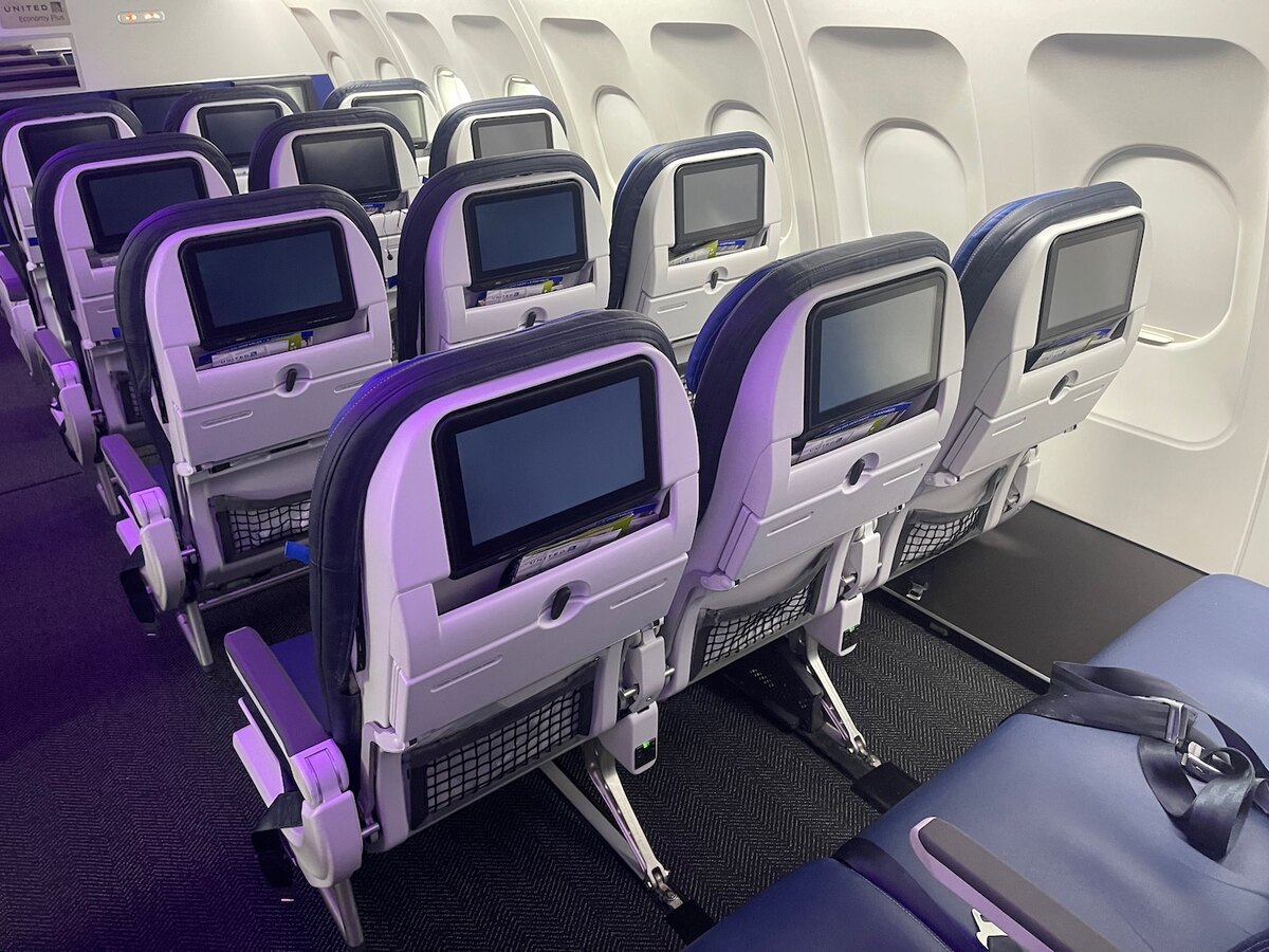 United Airlines A320 United Next economy cabin with seatback AVOD screens and purple LED mood lighting