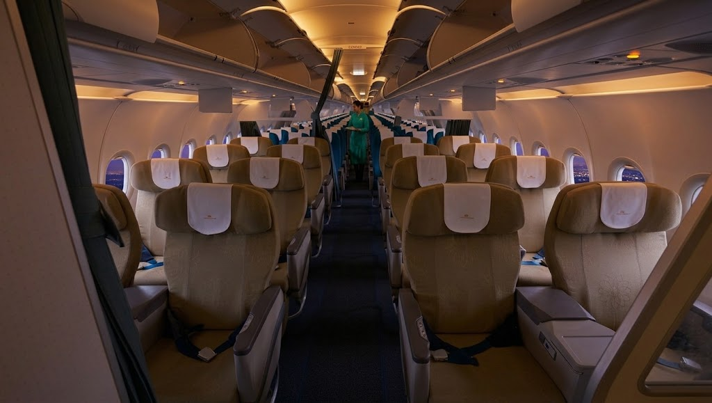 Vietnam Airlines Airbus A321 cabin, 2-2 business recliners in the foreground and 3-3 economy behind the curtain